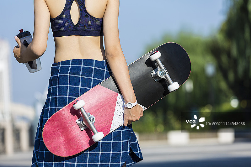 年轻女子拿着滑板图片素材