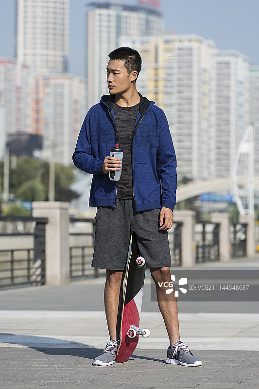 玩滑板的年轻男士运动后休息图片素材