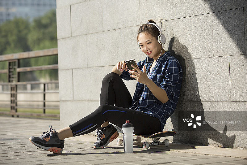 年轻子女运动后休息听音乐图片素材