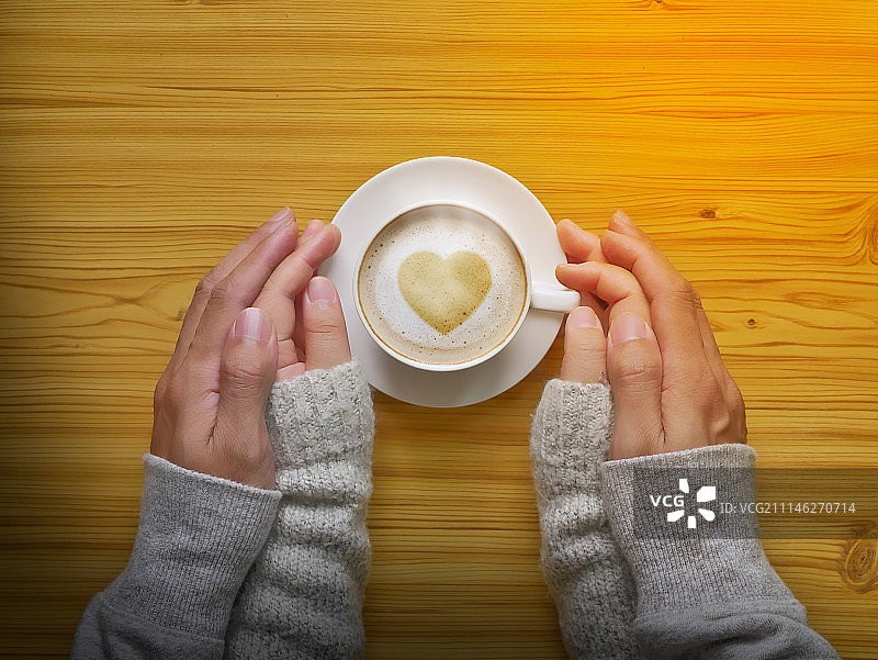 男女手捧心形热咖啡杯图片素材