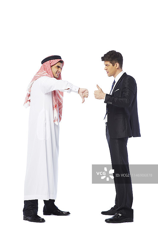 西装男士与穿坎杜拉长袍的男士用手势交流的影棚照图片素材