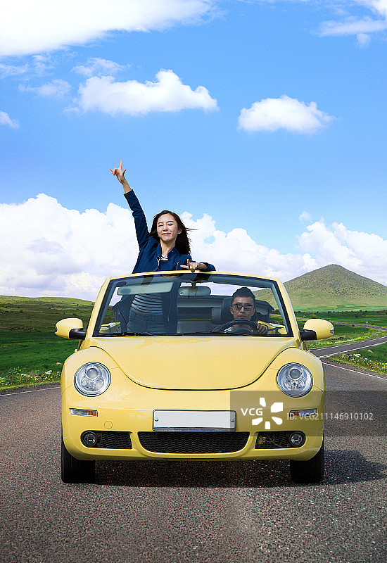 年轻夫妇驾驶敞篷车，女子站立摄影作品图片素材