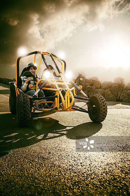 年轻男女在路上驾驶卡丁车的照片图片素材