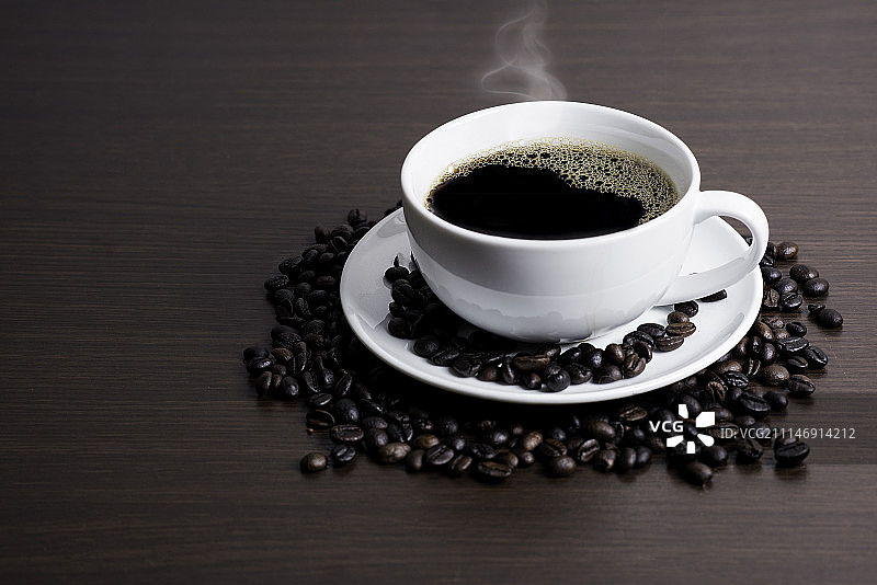 白色杯子里的黑咖啡和布上的咖啡豆图片素材