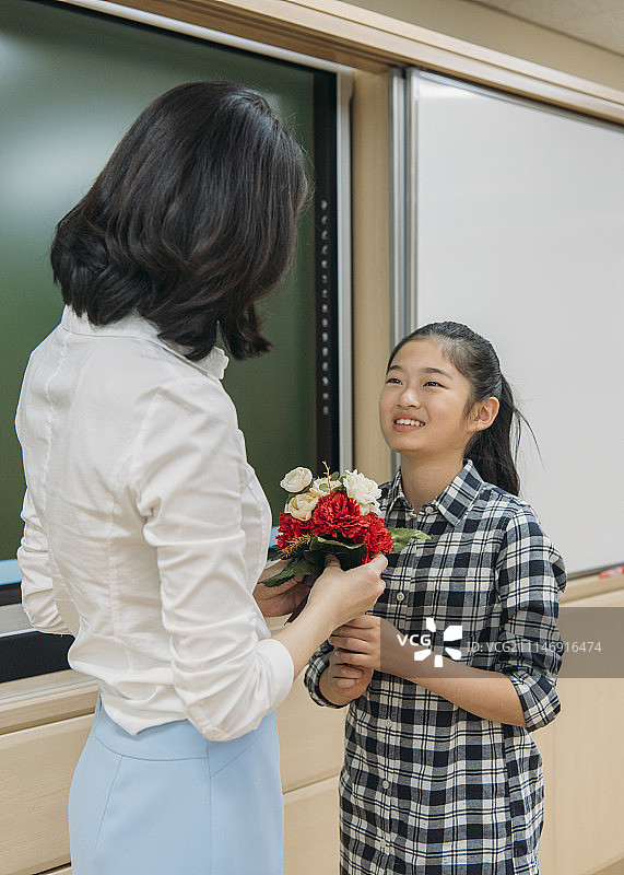 女孩送花给老师表达感激图片素材