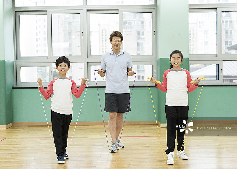 体育馆里和学生跳绳的老师图片素材