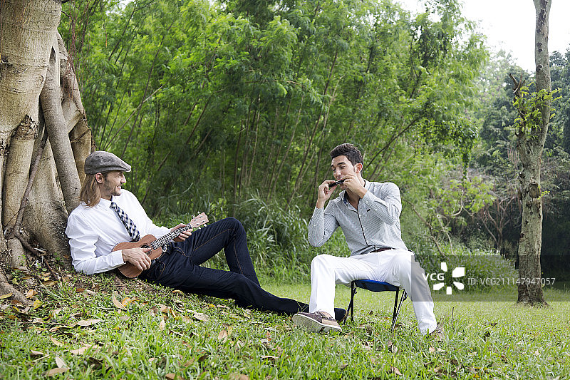 在golf球场上弹奏口琴和吉他的两个男人照片图片素材