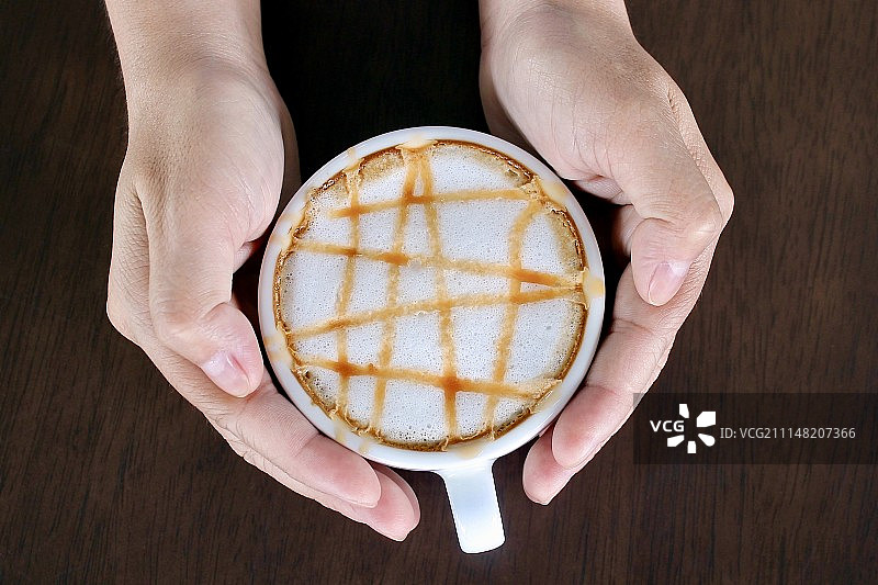 木质背景上的焦糖玛奇朵咖啡杯图片素材