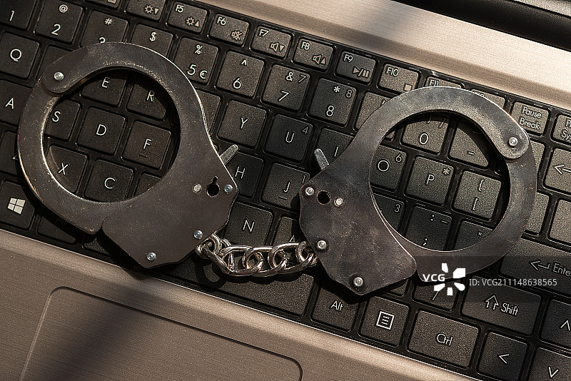 铁窗影子下的手铐及电脑图片素材