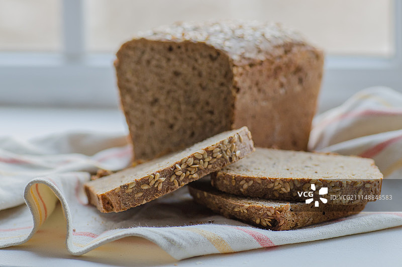 亚麻布上的一半自制黑面包切片图片素材