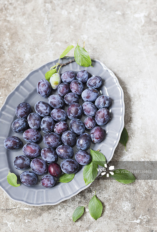 陶瓷盘上的新鲜李子图片素材