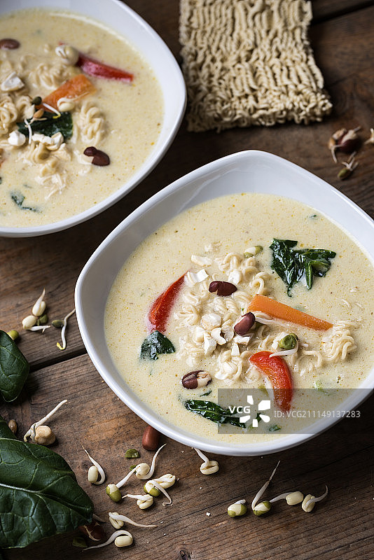 纯素椰奶咖喱汤配米粉、小白菜、辣椒、腰果和豆芽图片素材