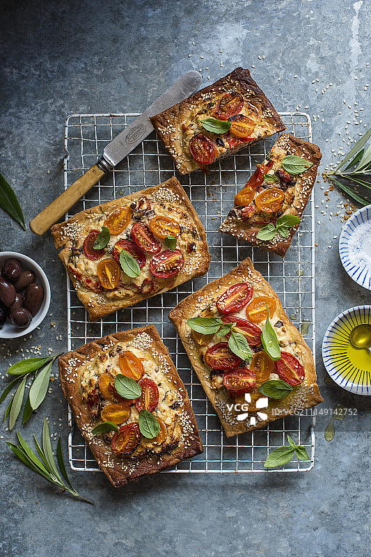 羊乳酪橄榄番茄脆皮馅饼，配芝麻和新鲜罗勒图片素材