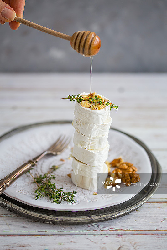 堆叠的山羊奶酪配核桃百里香和蜂蜜图片素材