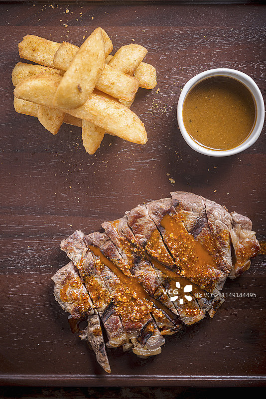 香料烤牛排配薯条和酱汁图片素材