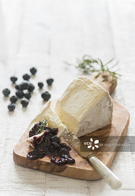 木板上软奶酪配蓝莓酸辣酱图片素材