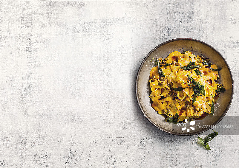 南瓜奶油意大利面配脆皮鼠尾草和南瓜子图片素材