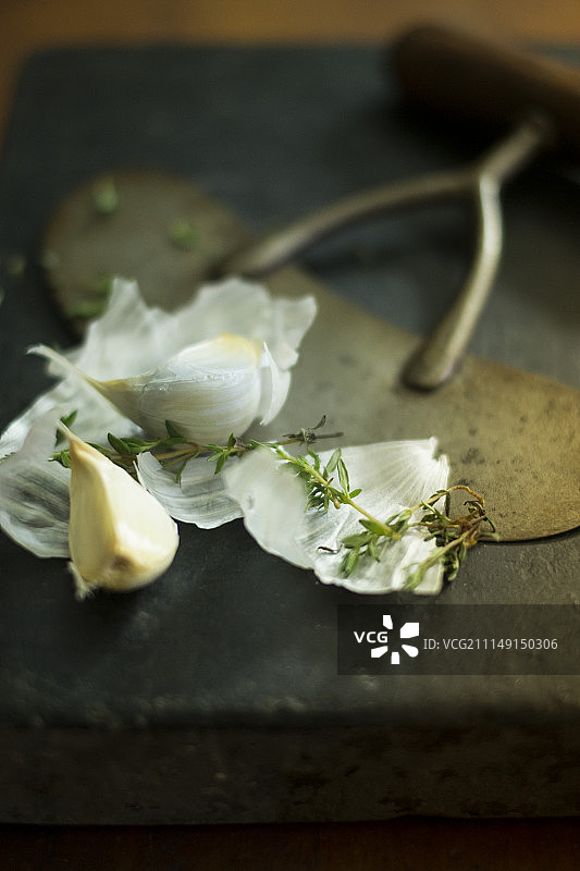 黑色砧板上的大蒜和百里香图片素材
