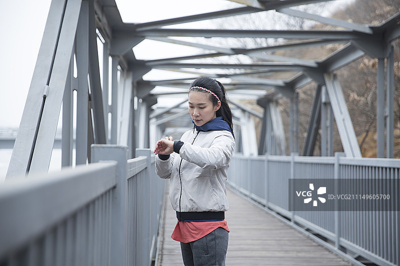 青年女子运动后查看智能手表图片素材