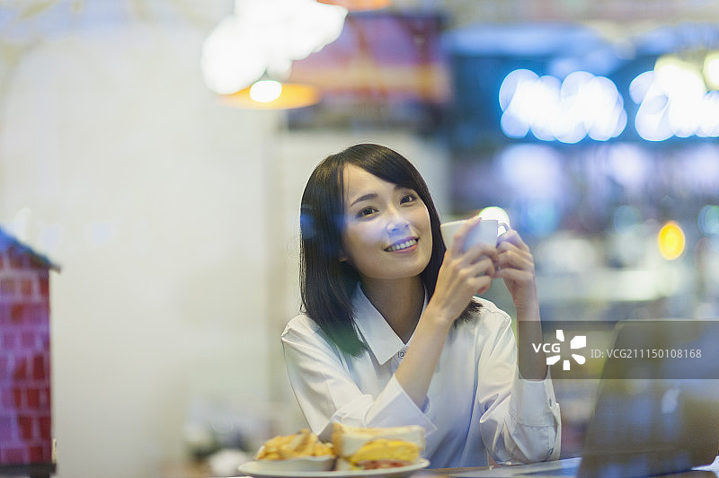 一位办公女性在吃下午茶图片素材