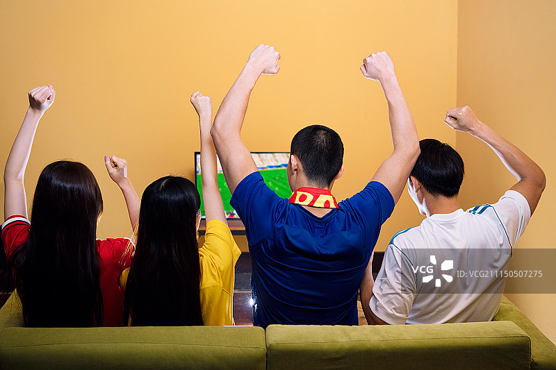 四个球迷在客厅聚会观看体育比赛图片素材