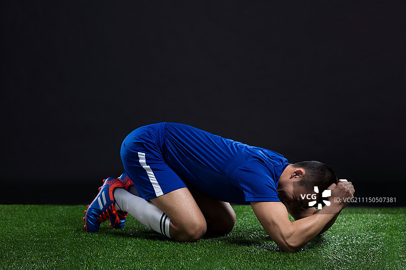 一名年轻足球运动员在草地上踢足球图片素材
