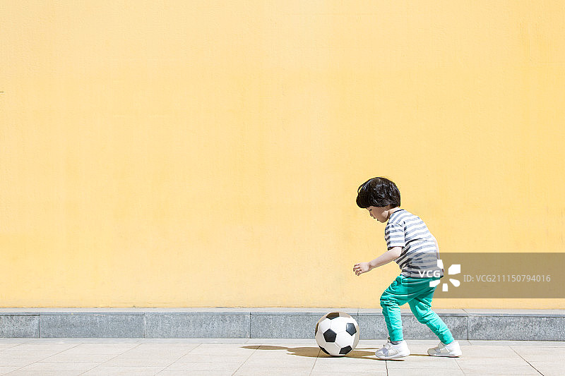 小男孩踢足球图片素材