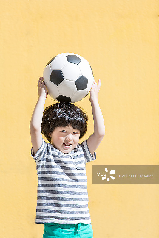 小男孩头顶足球图片素材