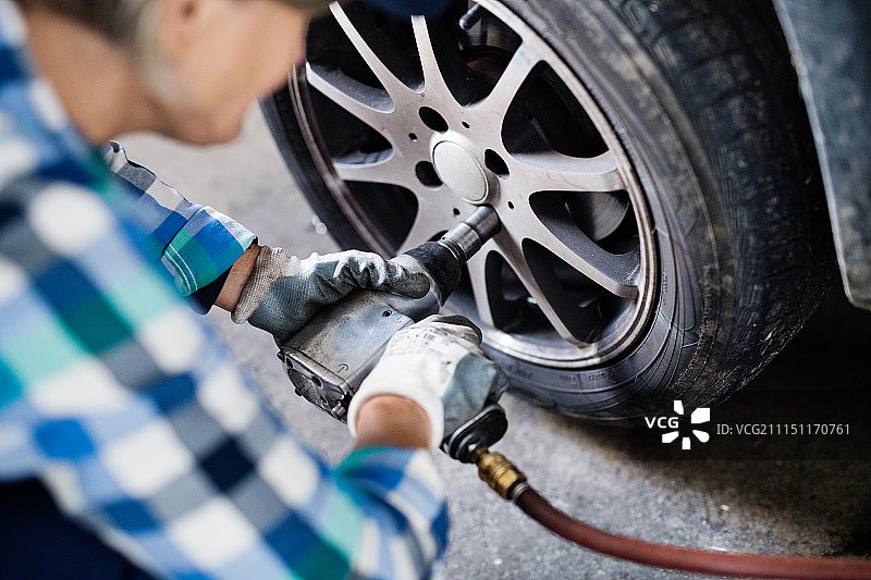 年长的女修理工在车库里修理汽车图片素材