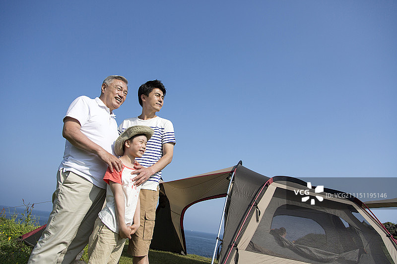 山坡上帐篷旁的一家摄影图片素材