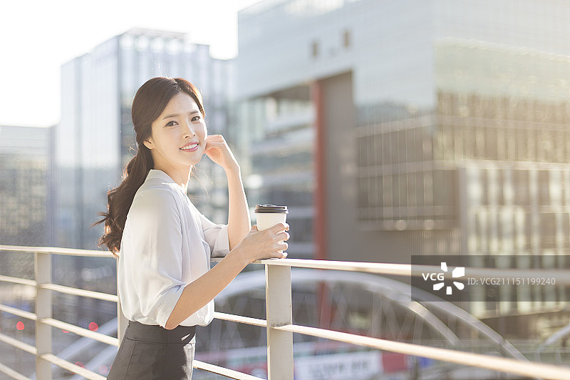 在阳台上喝咖啡休息的商务女性照片图片素材