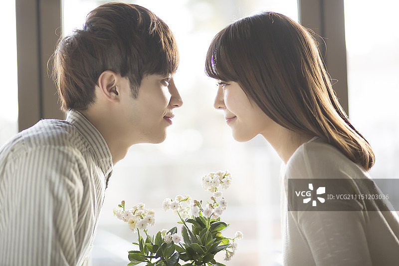 手捧花盆，双手紧握的年轻情侣，爱意浓浓图片素材