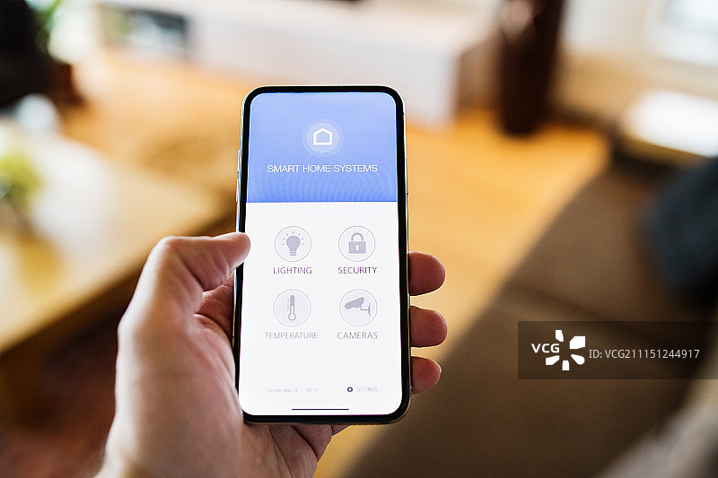 一位女士手持带有智能家居屏幕的智能手机图片素材