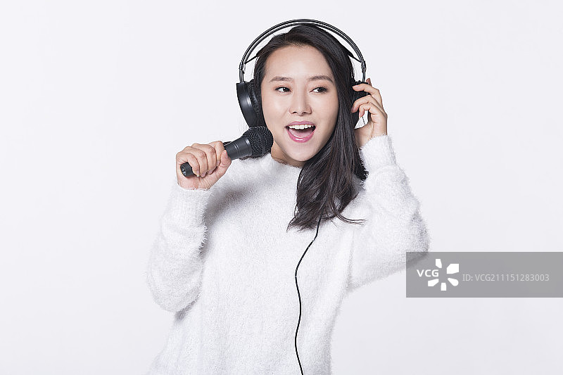 快乐的女孩拿着麦克风唱歌图片素材