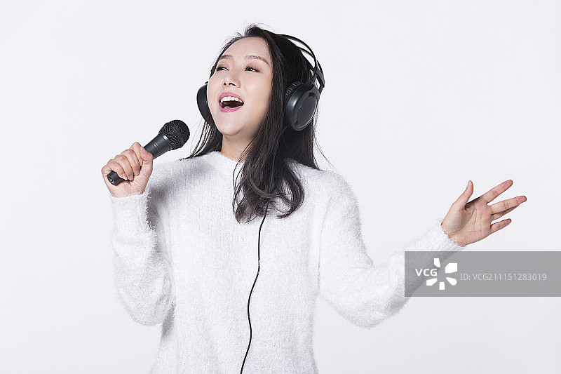 快乐的女孩拿着麦克风唱歌图片素材