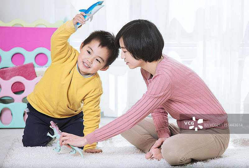 妈妈陪着儿子在客厅里一起做游戏图片素材