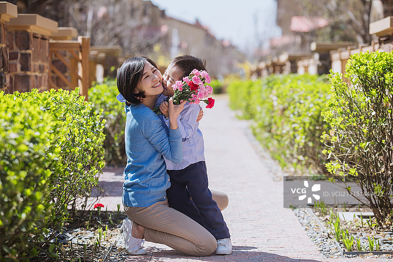 男孩给妈妈送康乃馨图片素材