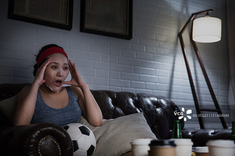 年轻女士贴面膜熬夜看世界杯图片素材