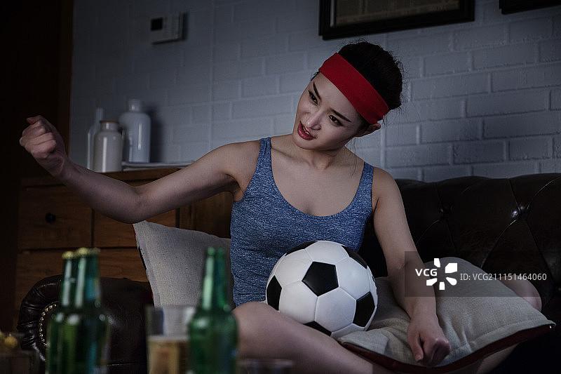 青年女士熬夜看足球图片素材