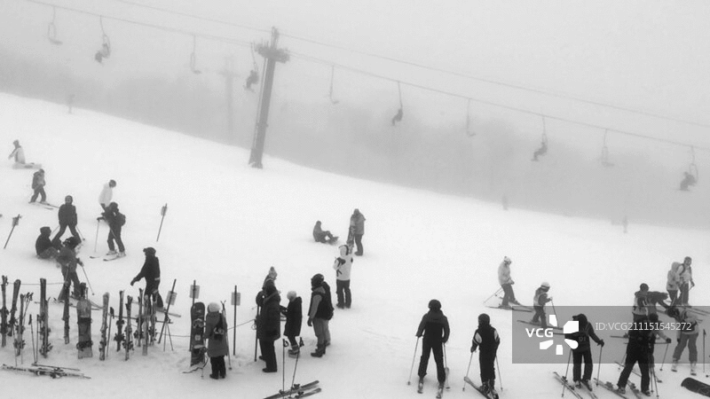滑雪者在下雪天在滑雪缆车附近休息图片素材