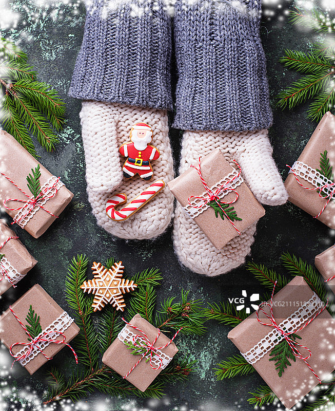 戴手套的手拿着圣诞礼物盒和姜饼图片素材