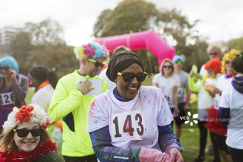 在公园慈善跑中，身上沾满彩色粉末的跑步女子图片素材