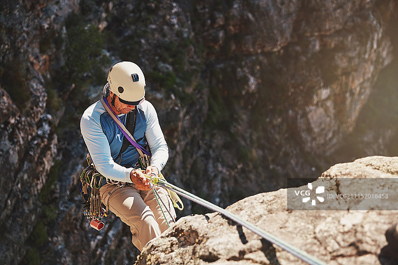 男性攀岩者绳降图片素材