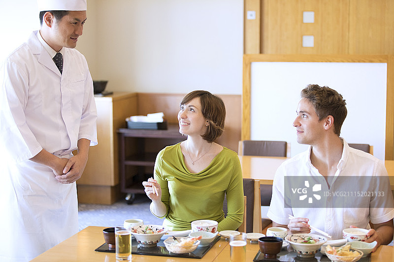 情侣与厨师交谈享用日本料理图片素材