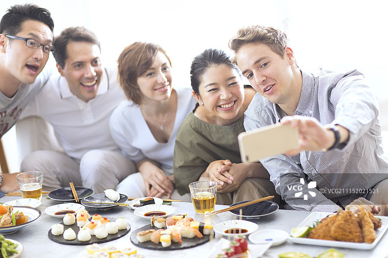 在家聚会拍照的年轻男女图片素材