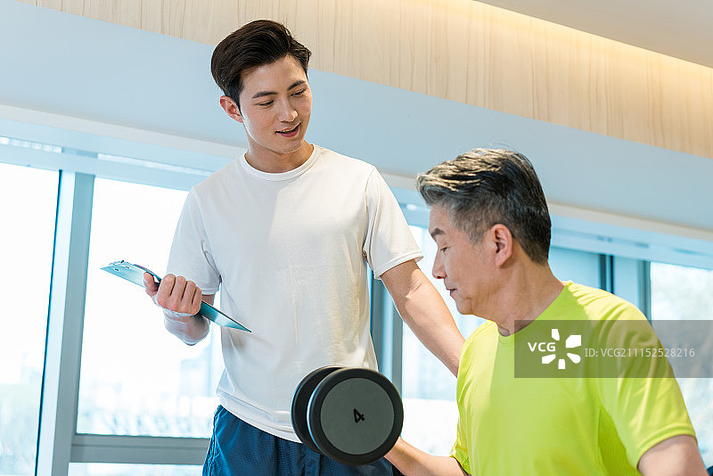 老年男子在私教的指导下健身图片素材