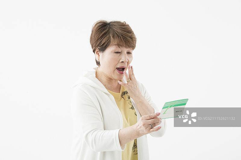 微笑的老年妇女看着存折图片素材