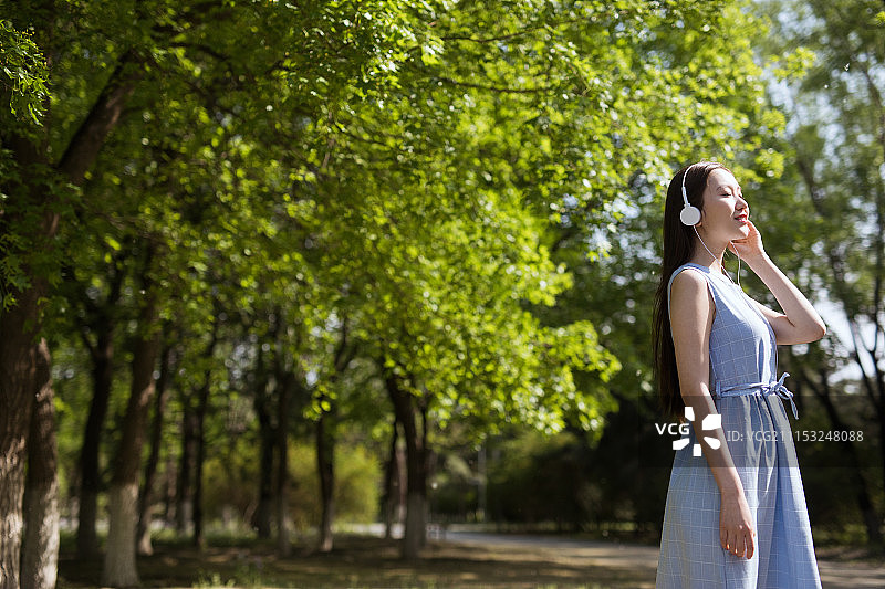 戴着耳机听歌的年轻女性图片素材