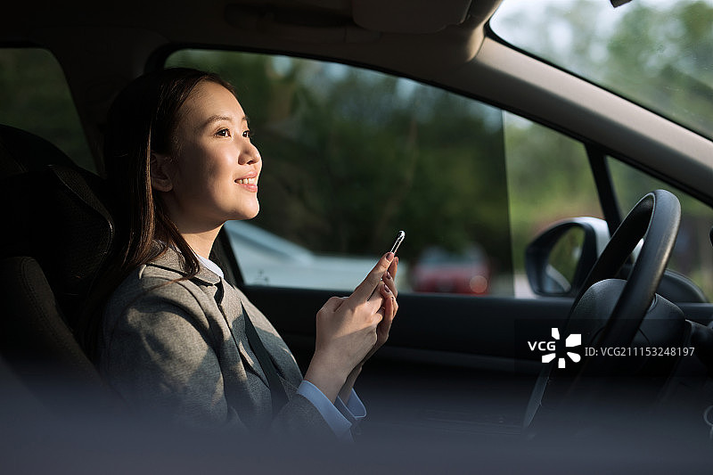 坐在车里打电话的年轻女性图片素材