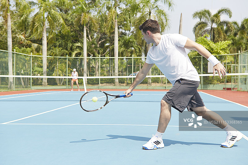 在网球场上打网球的男女图片素材